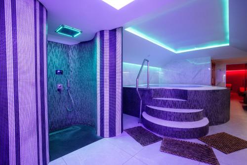 a bathroom with a shower and a staircase and a tub at Tresor Le Palais Timisoara, Curio Collection by Hilton in Timişoara