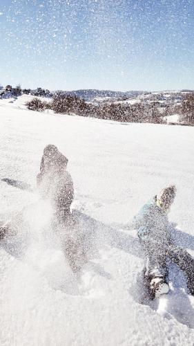 a person is playing in the snow at Dolina Białego Wilka - Niebieskie Domki in Zawóz