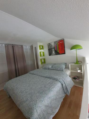 a bedroom with a bed and a green lamp at Très joli appartement Disneyland Paris 4 pers in Bussy-Saint-Georges
