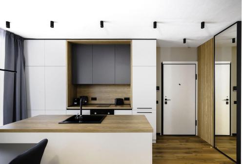a kitchen with white walls and a counter with a sink at Aviva Living by Flat Mаnager in Sofia
