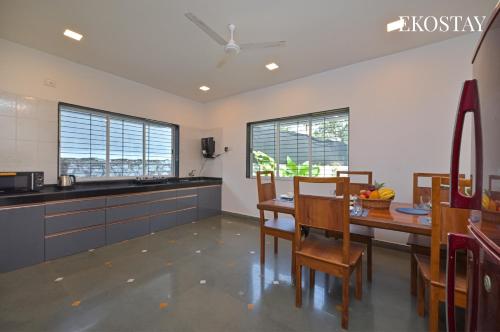 a kitchen with a table and chairs in a room at EKOSTAY - Serenity Villa in Alibaug