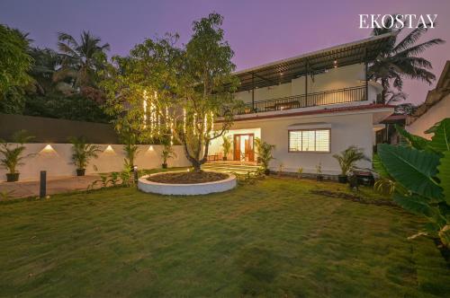a house with a tree in a yard at EKOSTAY - Serenity Villa in Alibaug