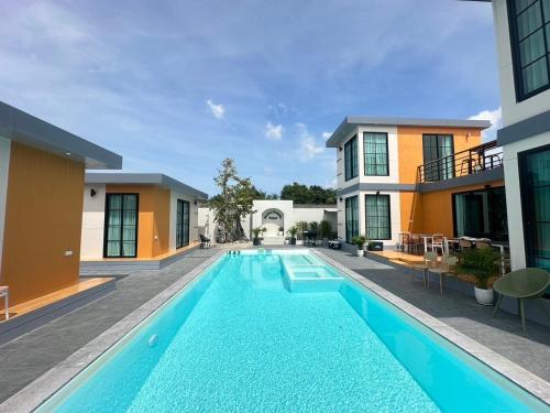 a swimming pool in front of a building at Dertera Poolvilla เดอเทร่าพูลวิลล่า หาดใหญ่ in Hat Yai