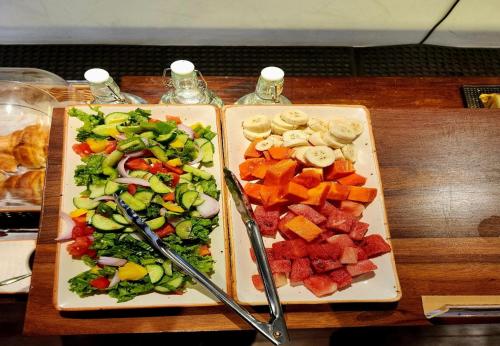 two plates of vegetables on a wooden table at La Papillon Maison in Puducherry