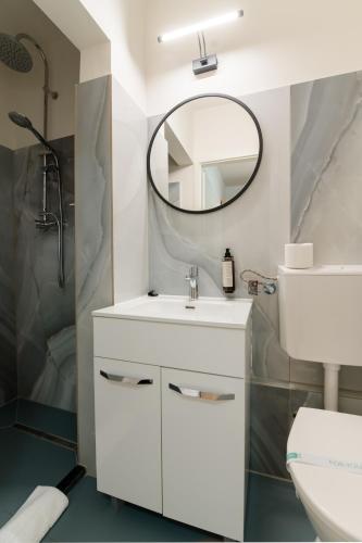 a white bathroom with a sink and a mirror at Hotel Royal Plaza By TimHotels in Timişoara