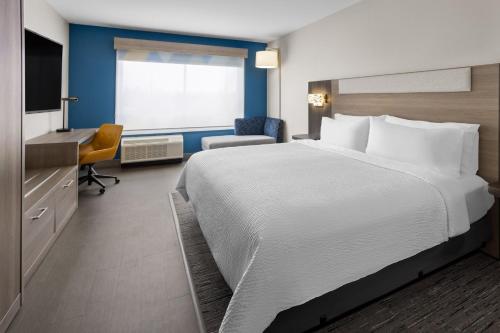 a hotel room with a large bed and a desk at Holiday Inn Express & Suites Waynesboro East in Waynesboro