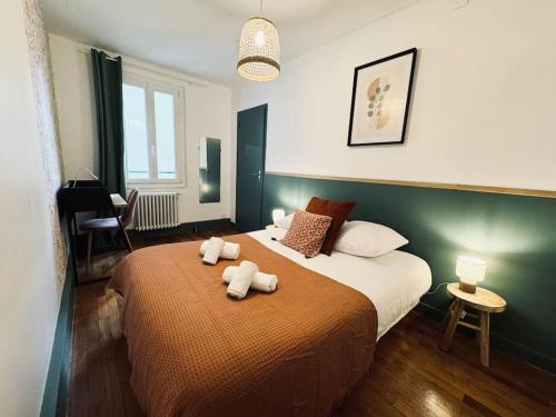 une chambre avec un lit avec deux animaux en peluche dessus dans l'établissement L'Evasion, Rennes, à Rennes