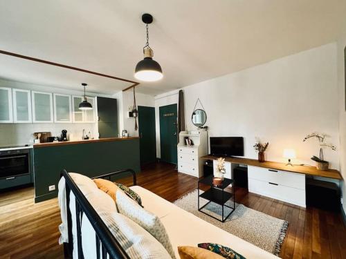 un salon avec un canapé et une cuisine dans l'établissement L'Evasion, Rennes, à Rennes