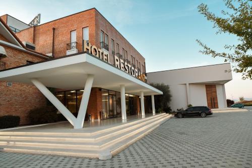 a building with a car parked in front of it at Hotel Albulena in Mamurras