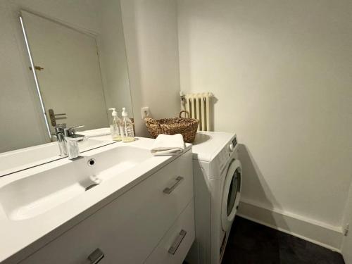 une salle de bain avec un lavabo et une machine à laver dans l'établissement L'Evasion, Rennes, à Rennes