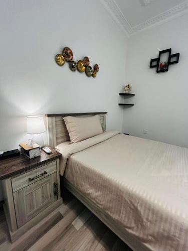 a bedroom with a bed and a table with a lamp at Sada Compound (Women Only) سيدات فقط in Riyadh