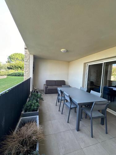 un patio avec une table, des chaises et un canapé dans l'établissement Appartement CUMARU vue mer, à Saint-Florent