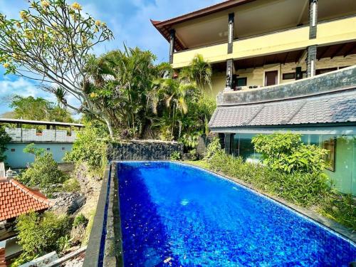 una piscina azul frente a una casa en View apartments with infinity pool in Nusa Dua Bukit Renovated in 2025, en Nusa Dua