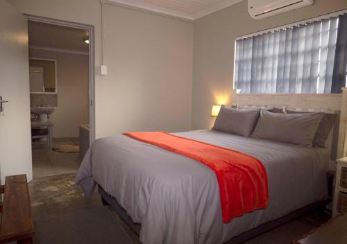 a bedroom with a bed with a red blanket on it at Fossil Hills in McGregor