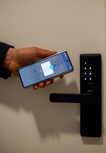 a person holding a cell phone in their hand at Hotel Royal Plaza By TimHotels in Timişoara
