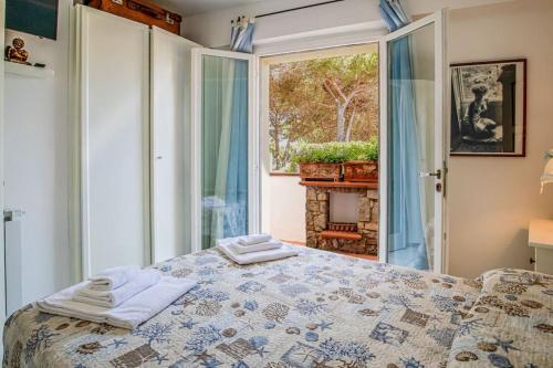 a bedroom with a bed and a large window at Villa Denise in Capoliveri