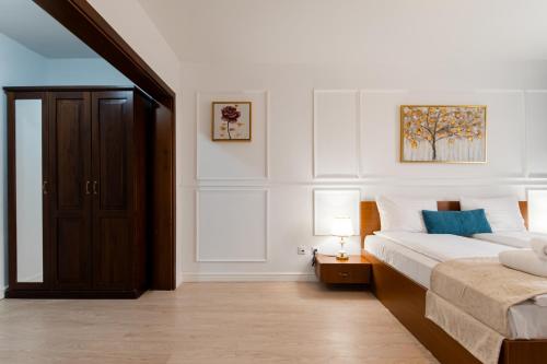 a white bedroom with a bed and two lamps at Hotel Royal Plaza By TimHotels in Timişoara