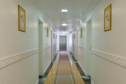 a long hallway with white walls and a long aisle at Hotel Royal Plaza By TimHotels in Timişoara