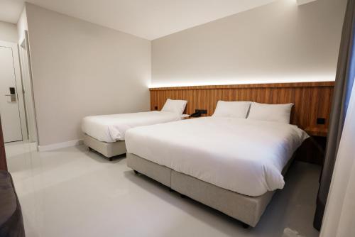Una cama o camas en una habitación de Joyful Hotel By Gnl