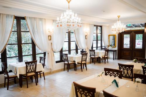 a dining room with tables and chairs and chandeliers at Hotel Royal Plaza By TimHotels in Timişoara