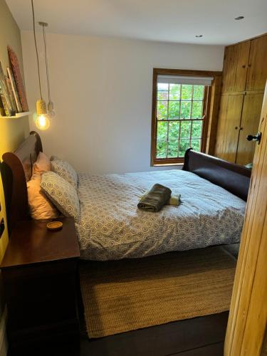 a bedroom with a bed and a window at Cosy Cottage (Free parking) in Macclesfield