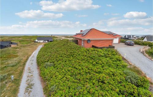 a house on a hill next to a road at 4 Bedroom Stunning Home In Thisted in Thisted