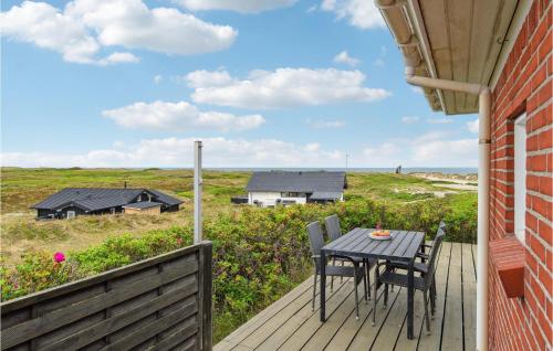 a table and chairs on a deck with a view of the ocean at 4 Bedroom Stunning Home In Thisted in Thisted