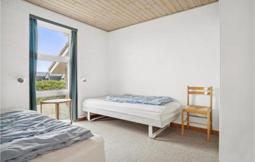 a bedroom with a bed and a chair and a window at 4 Bedroom Stunning Home In Thisted in Thisted