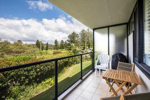 a balcony with a table and chairs and a view at Mona Vale Surf to Tee in Mona Vale