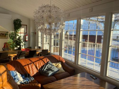 a living room with a couch and a chandelier at Äventyrsgårdens Vandrarhem, Kinnekulle in Källby