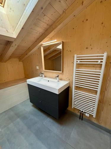 une salle de bain avec un lavabo et un miroir dans l'établissement Chalet des Freinets : proche centre de Châtel et au calme, à Châtel