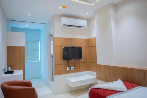 a bedroom with a bed and a tv on the wall at Hotel Ramkrishna Palace in Bijāpur