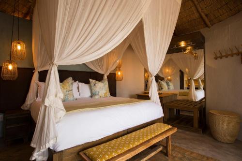 a bedroom with a bed with a canopy at Klaserie Drift Misava in Klaserie Private Nature Reserve