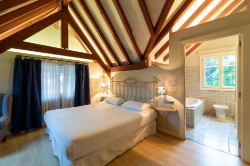 a bedroom with a large bed and a bath tub at KAIAN MAITEA in Plentzia