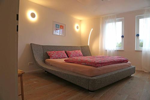 a bed with red pillows on top of it in a room at Ferienhaus Blaues Häuschen in Freudenberg am Main