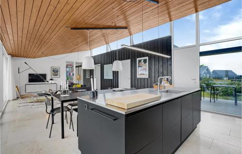 a kitchen with a sink and a table with chairs at Four-Bedroom Holiday Home In Lundby in Lundby