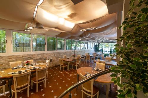 a restaurant with wooden tables and chairs and windows at KAIAN MAITEA in Plentzia