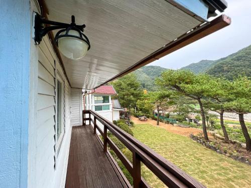 a balcony with a view of a yard at Pyeongchang The Meomum Pension in Pyeongchang 