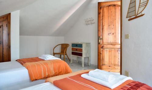 2 letti in una camera con scrivania e sedia di Villa Nodu Pianu Verde a Pittulongu