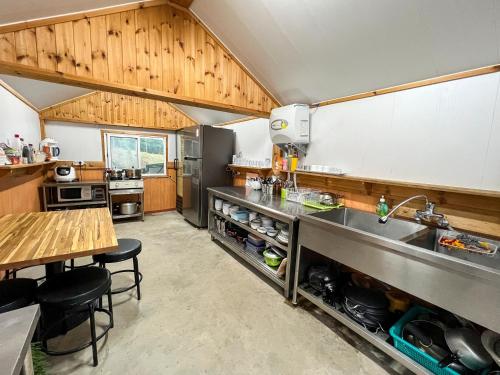a large kitchen with a sink and a counter at Pyeongchang The Meomum Pension in Pyeongchang 