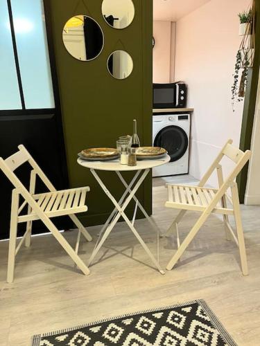 une cuisine avec une table, deux chaises et une table avec des assiettes. dans l'établissement Le petit Saint Mihel - Adolphe Moitié bleu, à Nantes