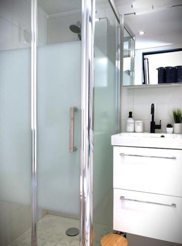 une salle de bain avec une douche, un lavabo et un miroir dans l'établissement Le petit Saint Mihel - Adolphe Moitié bleu, à Nantes