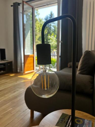 une lampe en verre sur une table dans le salon dans l'établissement Le Floraline-Au coeur d'Aix les bains - 3, à Aix-les-Bains