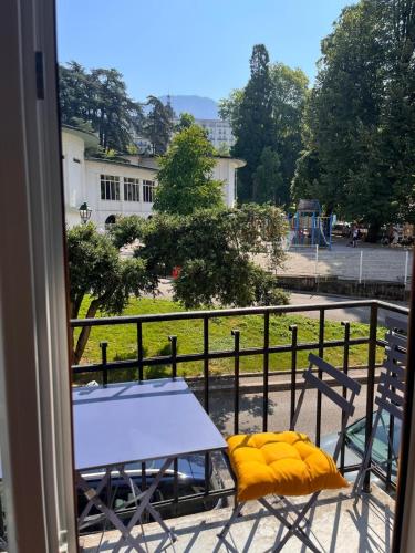 d'une table et de chaises sur un balcon avec vue sur un parc. dans l'établissement Le Floraline-Au coeur d'Aix les bains - 3, à Aix-les-Bains