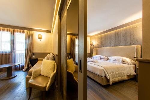 a hotel room with a bed and a chair at Hotel Spinale in Madonna di Campiglio
