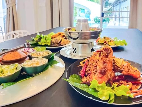 a table with several plates of food on it at 189Premier Villa Lamphun in Lamphun