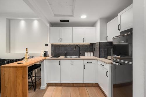 a kitchen with white cabinets and a wooden counter top at pisgat shoresh in Shoresh