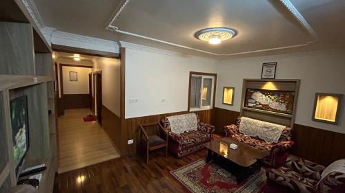a living room with two chairs and a tv at Raniban Suites - Apartment Home in Kathmandu