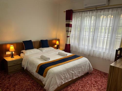 a bedroom with a large bed and a window at Raniban Suites - Apartment Home in Kathmandu