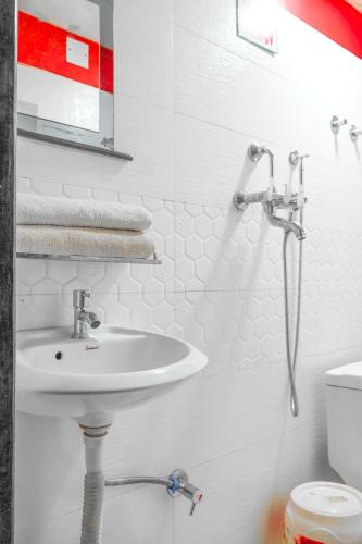 a white bathroom with a sink and a shower at RINGJI PALACE in Kakarvitta
